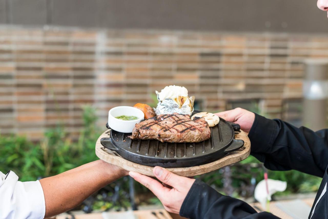 โรงแรมโมวิช ลาส โลมาส ริโอเนโกร ภายนอก รูปภาพ A waiter serving a steak